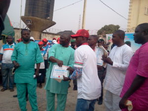 Hon Lasun presenting certificate to one of the beneficiaries. 